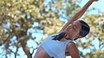 Fitness, woman and stretching arms outdoor for health, wellness and exercise. Pilates, meditation and Indian person or athlete training, exercising and warm up for running, cardio or workout at park.