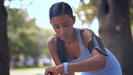 Running, woman and check smart watch outdoor for time, heart rate or fitness. Sports, Indian and athlete looking at wristwatch app to track workout performance, exercise progress or steps for cardio.