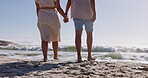 Walking, sand and holding hands with couple at beach for travel, love and summer vacation. Happy, relationship and romance with man and woman on date for bonding, affectionate and commitment