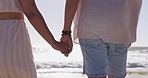 Closeup, love and couple on beach, holding hands and bonding on summer vacation, adventure and quality time. Romance, man and woman touching hand, zoom and walking on seaside holiday and journey