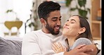 Love, hugging and couple on a sofa talking, bonding and spending quality time together in apartment. Happy, conversation and man embracing and kissing his girlfriend while relaxing in the living room