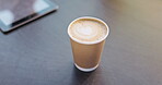 Coffee, takeaway and heart in a disposable cup on a desk in an office for fresh morning caffeine. Relax, cream and drink with a foam espresso on a table in a corporate workplace for business closeup