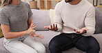 Couple, hands and divorce in disagreement or argument on sofa in living room dispute or unhappy relationship at home. Frustrated or upset woman and man talking in breakup or affair in conflict fight