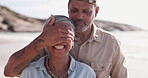 Covering eyes, surprise and couple at beach while happy and excited on summer vacation or holiday. Senior man and woman together for love, care and fun or happiness outdoor for travel in retirement