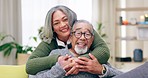 Relax, love and hug, portrait of old couple on sofa in living room in happy and mature relationship. Happiness, retirement and romance, senior man and woman enjoy embrace and quality time in home.