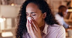 Business woman, sneeze and tissue in night at office with flu, sick and blowing nose for health at job. Young businesswoman, allergy and toilet paper for cleaning, covid or cold in dark workplace