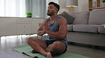 Meditation, zen and man doing yoga in a home lounge or living room as exercise, workout and fitness in a house. Calm, training and male meditating for wellness, health and as a spiritual