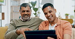 Tablet, wave or video call with a man and his father sitting on a sofa in the living room of their home together. Tech, contact or virtual chat with a senior dad and son waving to greet family