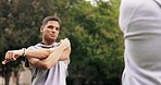 Fitness stretching, personal trainer and outdoor of an athlete talking before sports and workout. Arm stretch, warm up and exercise of a male runner in a park for running training with client