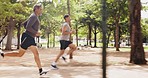 Men, running and outdoor park with athlete profile doing fitness, workout and run training. Nature trail, wellness and exercise of a male friends doing sports cardio for health and exercising goals