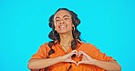 Smile, love hand gesture and woman on studio backdrop with mockup, freedom and support. Happy face of gen z model, heart hands and girl with creative lifestyle, kindness and care on blue background.