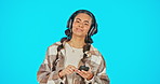 Woman, face and headphones with smartphone, dancing with smile and listening to music on blue background. Mockup, fun and freedom with portrait, female with radio mobile app and technology in studio