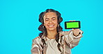 Woman, green screen and phone in studio advertising website, mobile app or network connection. Portrait of happy gen z female model point at smartphone in hand for brand or logo product placement