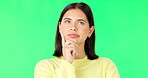 Face, thinking and decision with a woman on a green screen background in studio to consider an option. Idea, mind and contemplating with an attractive young female looking thoughtful on chromakey
