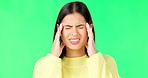 Stress, frustrated and a woman with a headache on a green screen isolated on a studio background. Burnout, anxiety and a girl massaging her temples to relieve migraine pain on a mockup backdrop