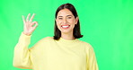 Ok, green screen and portrait of woman doing a perfect sign or hand gesture isolated in a studio background. Excited, happy and female showing approval, accept and agreement signal for perfection
