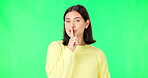 Green screen, happy face and secret woman with finger on lips, wink and privacy in studio. Portrait of female model, silence and shush for quiet, gossip and whisper emoji for confidential surprise