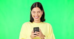 Laughing, woman and smartphone on green screen, studio and reading social media post, online chat and meme. Happy female model typing on cellphone, download mobile games and texting on background 