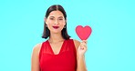 Face, smile and woman with red heart, emoji and romantic support against a blue studio background. Portrait, female or confident person with symbol for love, flirty and passion for romance and loving