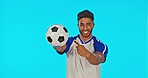 Soccer ball, man smile and pointing in studio isolated on a blue background mockup. Face portrait, football sports and happy Indian athlete with advertising, marketing or product placement for brand.