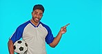 Soccer ball, man isolated in studio and pointing to a blue background mockup. Face portrait, football sports and happy Indian athlete with advertising, marketing or product placement for branding.