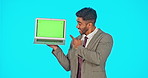 Green screen, laptop and man pointing, thumbs up and like isolated on blue background for business mockup space. Ok, yes and winning face of professional person on computer and advertising in studio