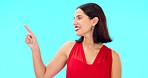 Woman, pointing and studio with happiness and smile showing mockup for advertisement. Portrait, isolated and blue background with a happy young female point to show mock up announcement and sign