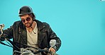 Freedom, motorbike and male with a helmet in a studio before going for a ride for training. Sports, adventure and punk man biker with sunglasses, leather jacket and bike isolated by blue background.