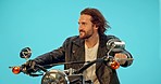 Motorbike, studio and man with travel on a ride adventure with wind in hair and confidence. Male model, isolated and blue background of a young person thinking on motorcycle on a road trip journey