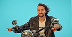 Motorbike, studio and man with travel on a ride adventure with wind in hair and confidence. Male model, isolated and blue background of a young person thinking on motorcycle on a road trip journey