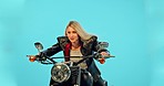 Motorbike travel, studio and woman with a smile on a ride adventure with wind in hair and confidence. Female model, isolated and blue background of a person on motorcycle on a road trip journey