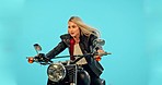 Motorbike, studio and woman with travel freedom on a ride adventure with wind and confidence. Model, isolated and blue background of a young person thinking on motorcycle on a road trip journey