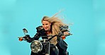 Motorbike, studio and woman with freedom on a ride adventure with wind in hair and confidence. Model, isolated and blue background of a young person thinking on motorcycle on a road trip journey