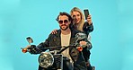 Selfie, blue background and couple on motorcycle with phone for adventure, road trip and holiday mockup. Motorbike, transport and man and woman take picture for social media, post or memory in studio