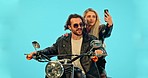 Selfie, studio and couple on motorcycle with phone for adventure, road trip and holiday mockup. Motorbike, transport and man and woman take picture for social media, post or memory on blue background