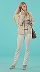 Phone call, coffee and annoyed business woman in studio on blue background with problem, issue or bad mood. Smartphone, conversation and female frustrated while walking on commute, trip or travel