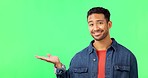 Face, pointing and man in a studio with green screen for advertising, marketing or product placement. Happy, smile and portrait of an Indian male model showing mockup space by a chroma key background