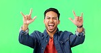 Face of a man with a rock gesture by green screen listening heavy metal music, playlist or album. Happy, portrait and male model with a punk hand sign streaming a grunge song by chroma key background