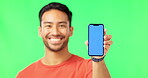 Asian man, phone and mockup on green screen with tracking markers against a studio background. Portrait of happy male showing mobile smartphone display for product placement, advertising or marketing