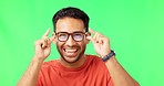 Glasses, face and male in a studio with green screen for optical awareness, wellness and health. Wink, flirt and portrait of an Indian man model with spectacles for eye care by chroma key background.
