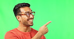 Face, marketing and pointing with a man on a green screen background in studio for advertising or product placement. Portrait, hand gesture or space with a handsome young male in glasses on chromakey