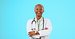 Happy black woman, portrait or doctor in studio isolated on blue background with smile or positive mindset. Space, face or proud African nurse smiling with arms crossed medical healthcare advice