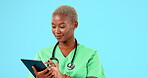 Tablet, doctor or happy black woman isolated on blue background in healthcare research, hospital or telehealth services. Nurse, surgeon or medical person typing on digital  or data software in studio