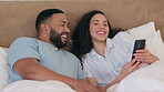 Phone, bed and happy couple relax with social media post, mobile app or reading a funny post at home. Young people or biracial woman and partner on smartphone, online or laughing at meme in bedroom