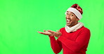 Showing, face and a man for Christmas on a green screen isolated on a studio background. Excited, happy and a portrait of a guy dressed in festive clothes gesturing to mockup space for branding