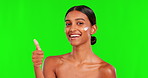 Skincare, cream and thumbs up with a woman on a green screen background in studio for natural beauty. Portrait, lotion or antiaging with a happy young female model in agreement on chromakey mockup