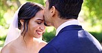 Wedding, bride and groom kissing in garden for celebration of love, care and commitment of life partner. Happy couple, forehead kiss and celebrate trust, loyalty and smile in support, summer and face