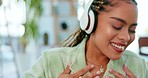 Music, dance and happy woman with headphones in a living room, smile and celebrating freedom on blurred background. Dancing, celebration and girl excited for radio, podcast or online audio track