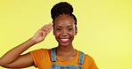 Salute, happy and portrait of a black woman greeting hand gesture with a smile isolated in a yellow studio background. Proud, welcome and young female with pride and confidence sign in backdrop