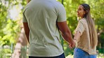 Back of happy couple, walking and holding hands in park for love, date and relax for freedom in garden. Man, woman and hand in nature for trust, loyalty and care of quality time together in sunshine